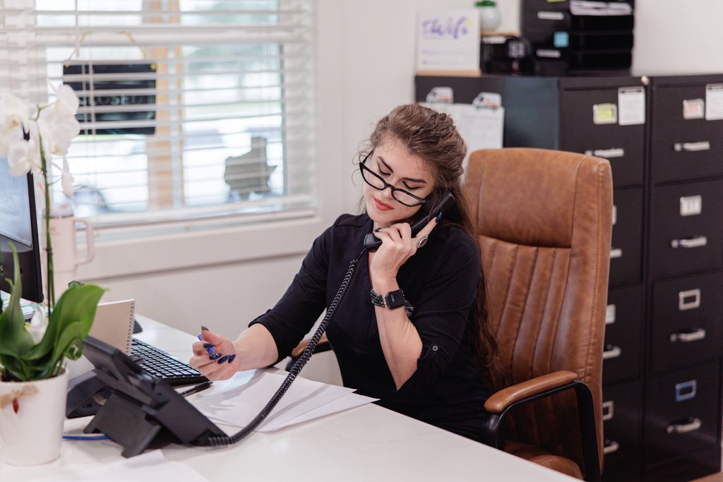An employee of JB Crawford Construction speaks to a client on the phone about a custom home build.